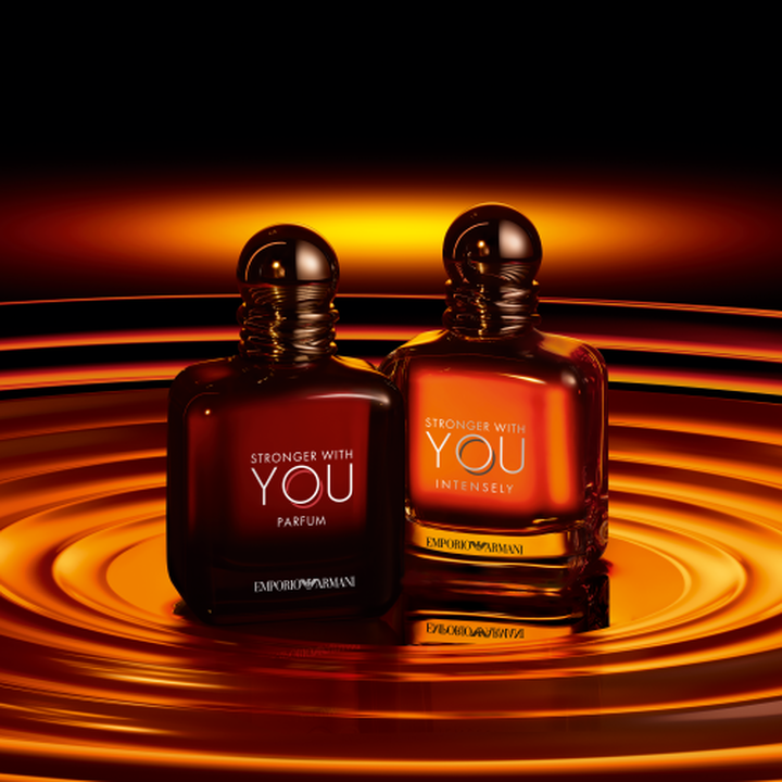 Emporio Armani Stronger With You Parfum and Stronger With You Intensely bottles, warm amber tones with swirling golden ripples background​