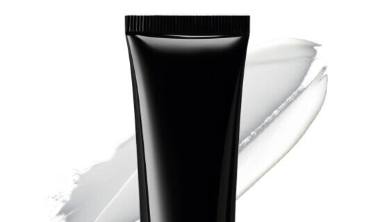 A black squeeze tube of cream with a white paint smear in the background.