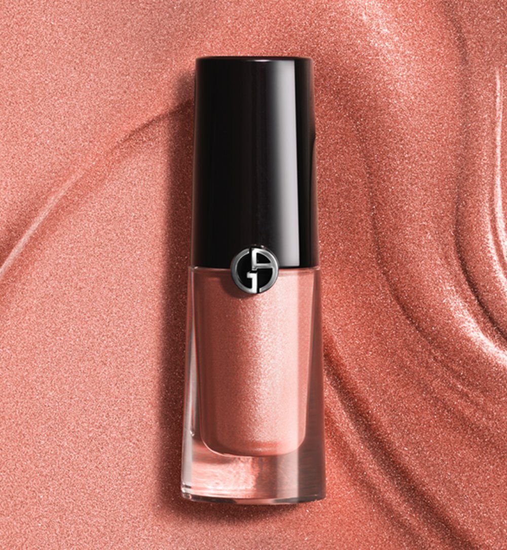 Giorgio Armani Eye Tint liquid eyeshadow in a shimmery rose-gold shade, displayed on a silky copper-toned texture background.