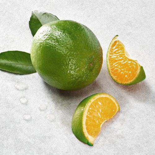 A whole green orange surrounded by two orange segments and green leaves on a light background.