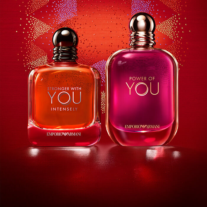 Two Emporio Armani fragrances, Stronger With You Intensely and Power of You, against a red festive background.​