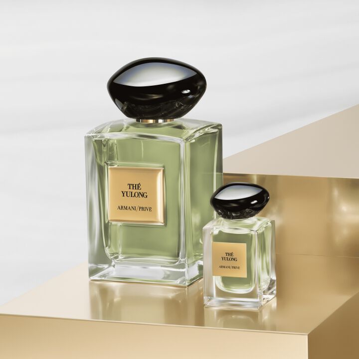 Two bottles of Armani Prive The Yulong perfume on a gold stand.