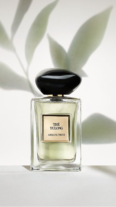 Bottle of Armani/Prive The Yulong against a light green  background leaf shadows.