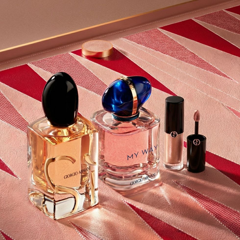 A luxurious selection of Armani icons: the intense Si and radiant My Way fragrances stand alongside an elegant makeup essential. Set on a couture-inspired pink and red geometric background, reflecting timeless beauty and craftsmanship.