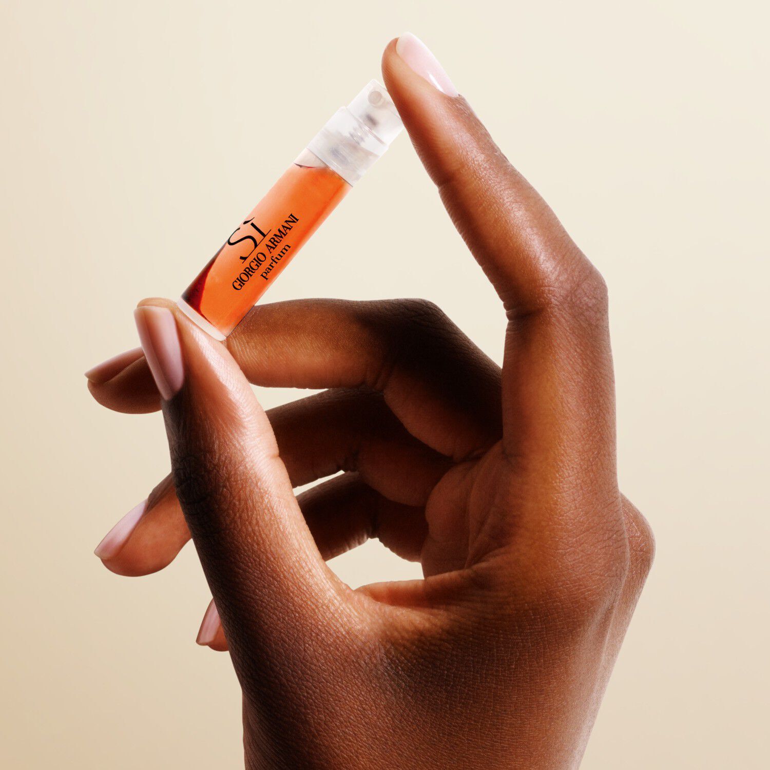 One hand holds a sample of SI PARFUM.