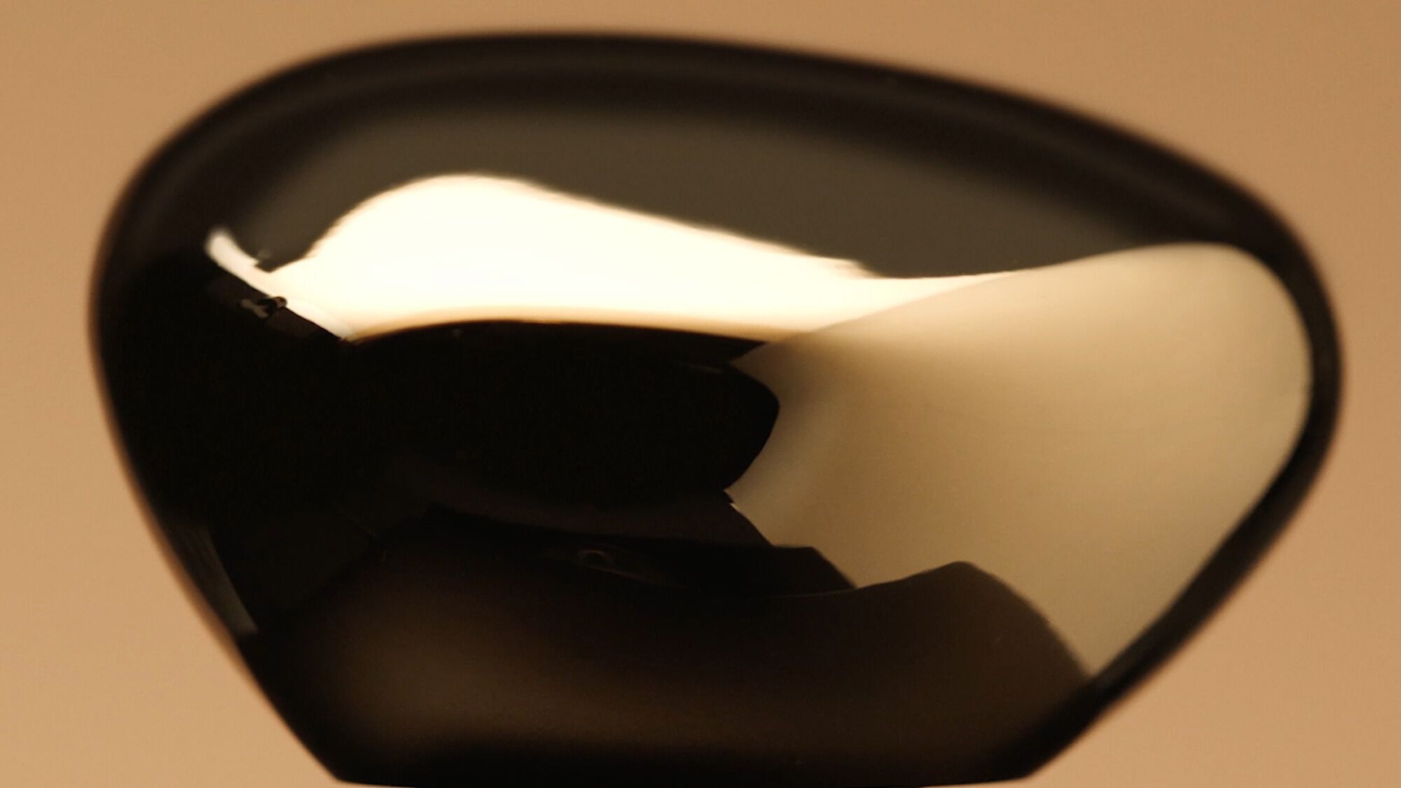 Armani/Prive Oud Royal: close-up of the signature onyx-colored glass cap with golden reflections, showcasing the fragrance’s iconic, luxurious bottle design.