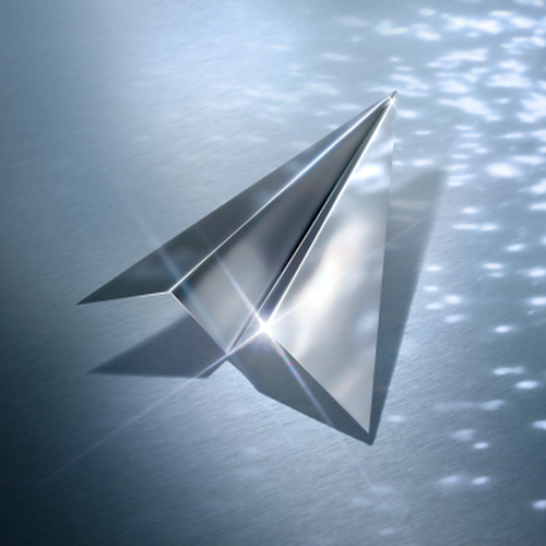 Metallic paper airplane on a shiny surface.