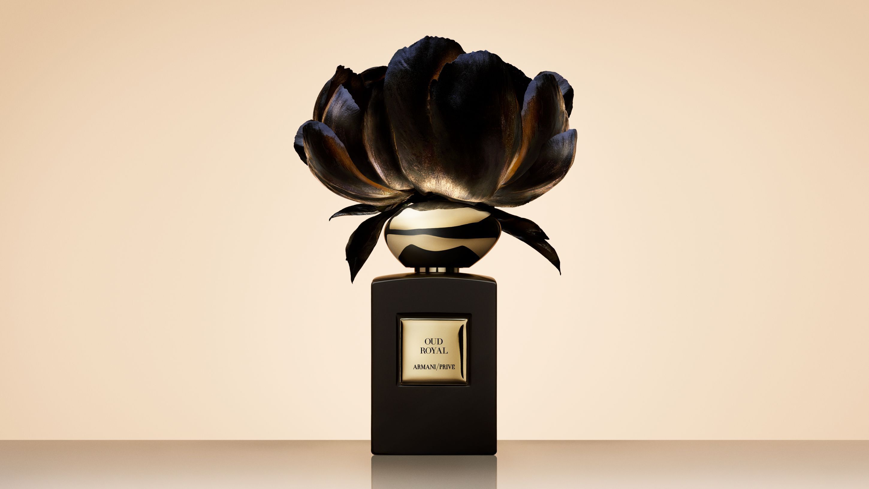 Armani/Prive Oud Royal perfume bottle topped with a large, artistic black flower.