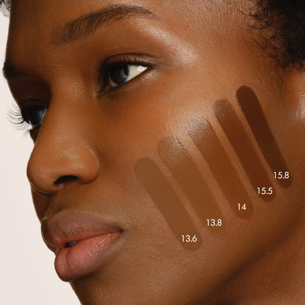 Close-up of a model's cheek with five swatches of LUMINOUS SILK FOUNDATION in shades