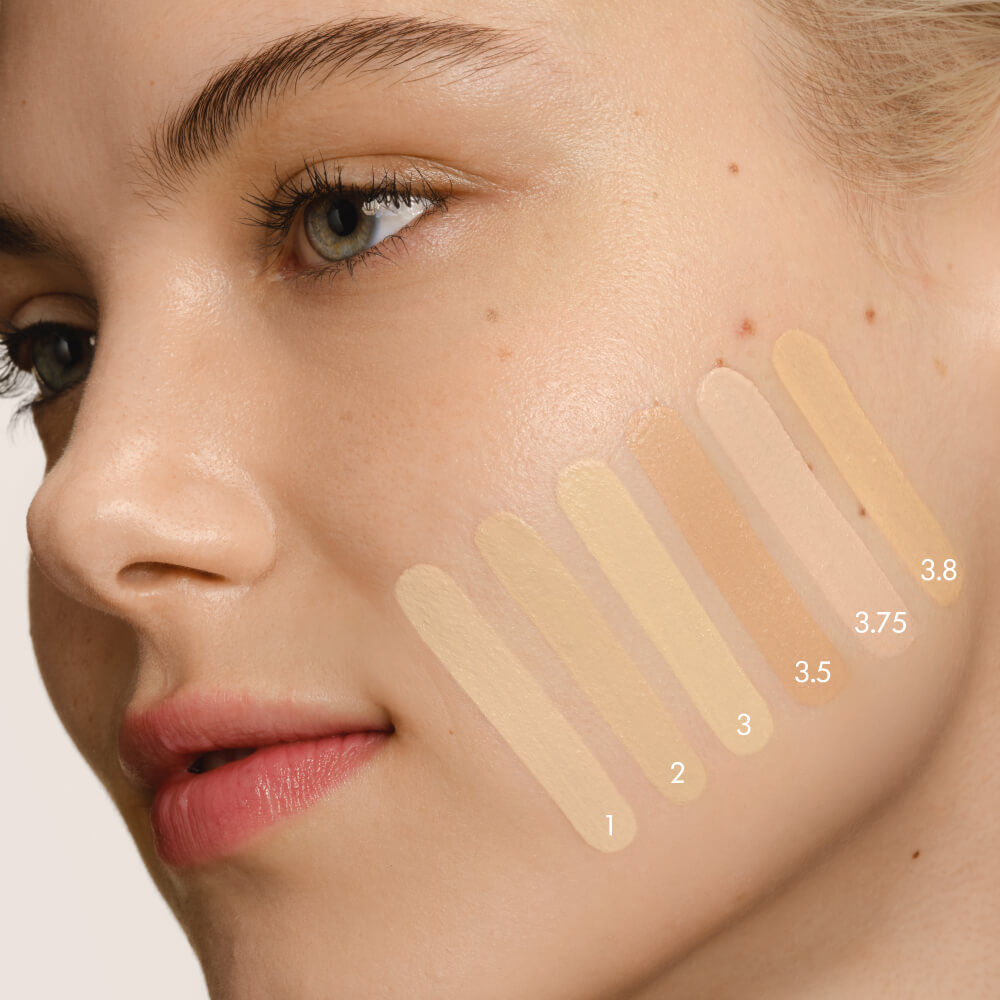 Close-up of a model's cheek with five swatches of LUMINOUS SILK FOUNDATION in shades