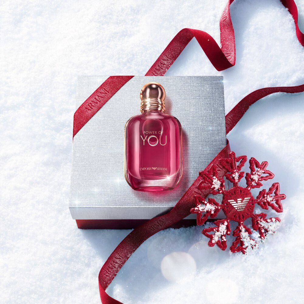 Ruby Power of You Eau de Parfum bottle with red Armani ribbon and jewelled snowflake on a snowy surface — Emporio Armani women's fragrance, holiday gift set visual.