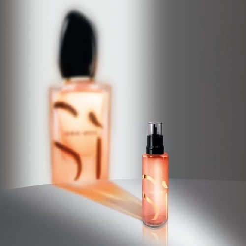 Three Giorgio Armani Si fragrance bottles: a tall spray, a square bottle, and a black cap, elegantly displayed on a soft background.