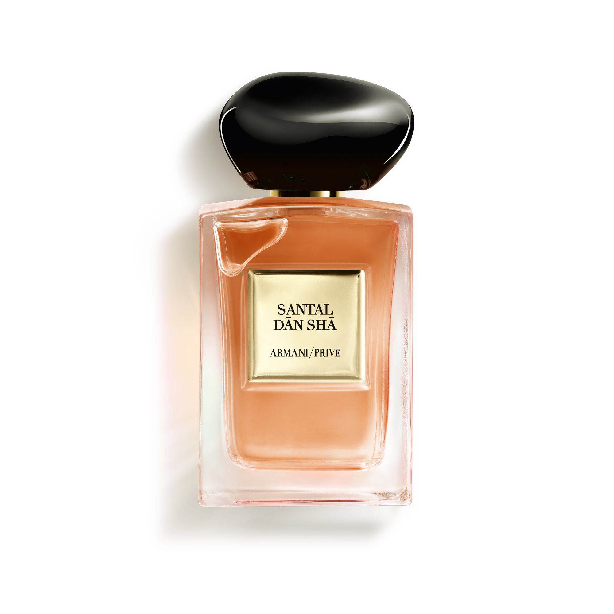 A bottle of Armani Privé Santal Dan Sha fragrance, featuring a minimalist design with a black cap and gold label.