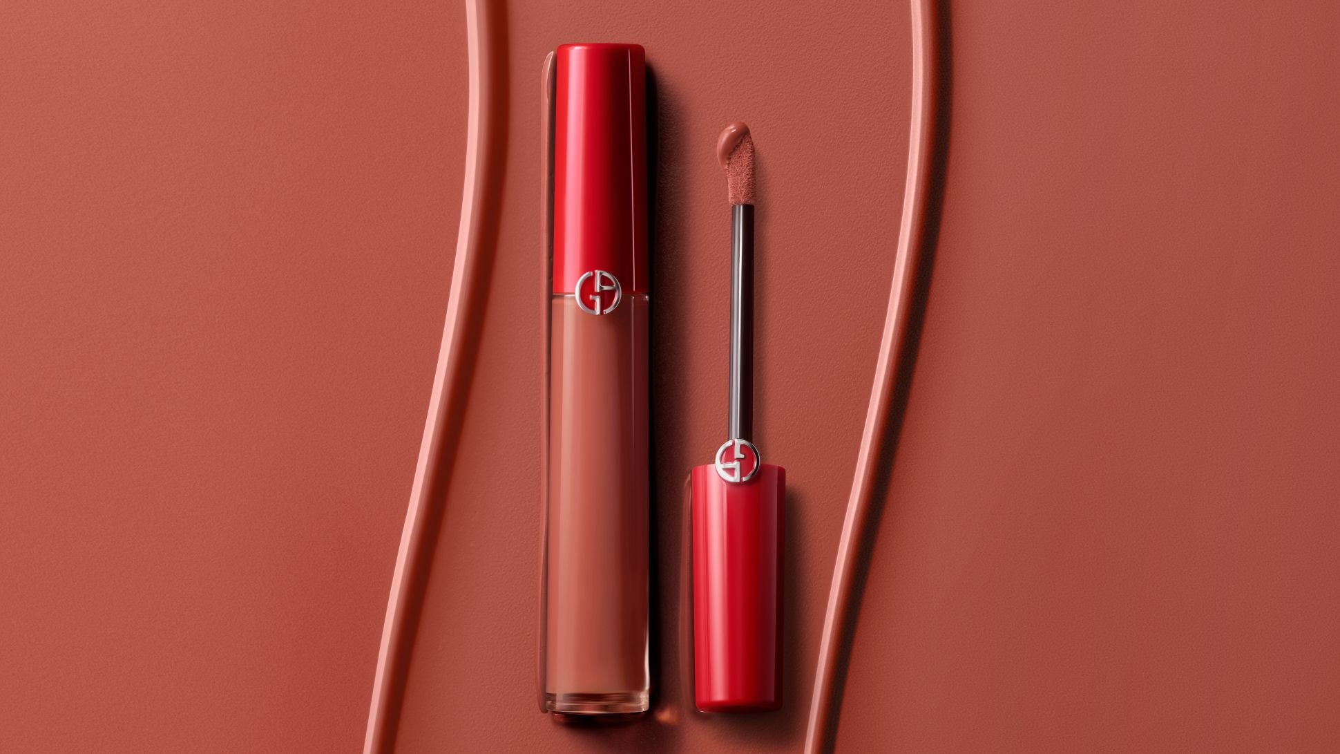 Giorgio Armani liquid lipstick with applicator on a textured terracotta background.